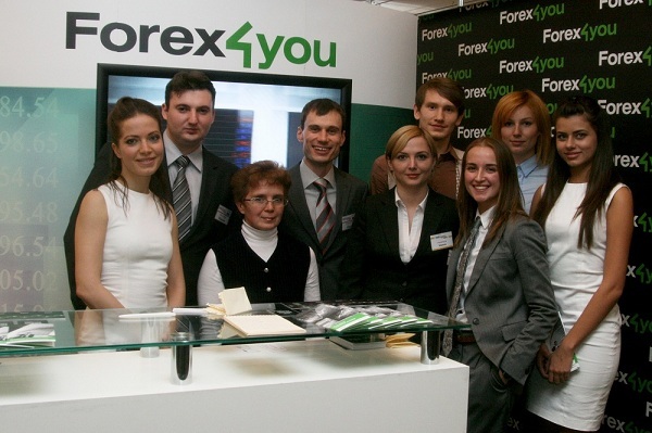 เจ้าหน้าที่ Forex4you ยืนข้างบู๊ทของบริษัทที่งาน Moscow Expo พฤศจิกายน 2011